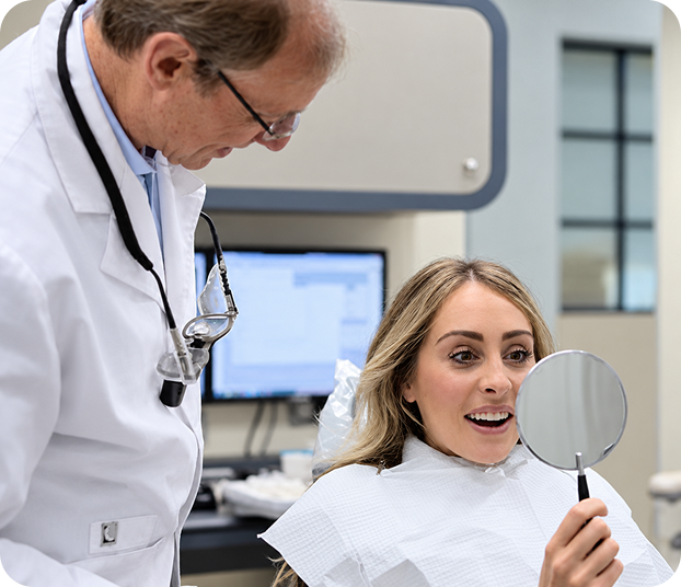 Dentist showing a patient the results of her treatment